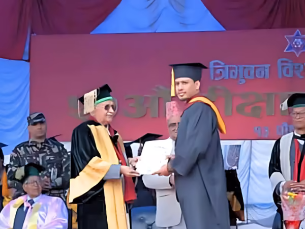 A graduand receiving a certificate on stage at a Tribhuvan University convocation