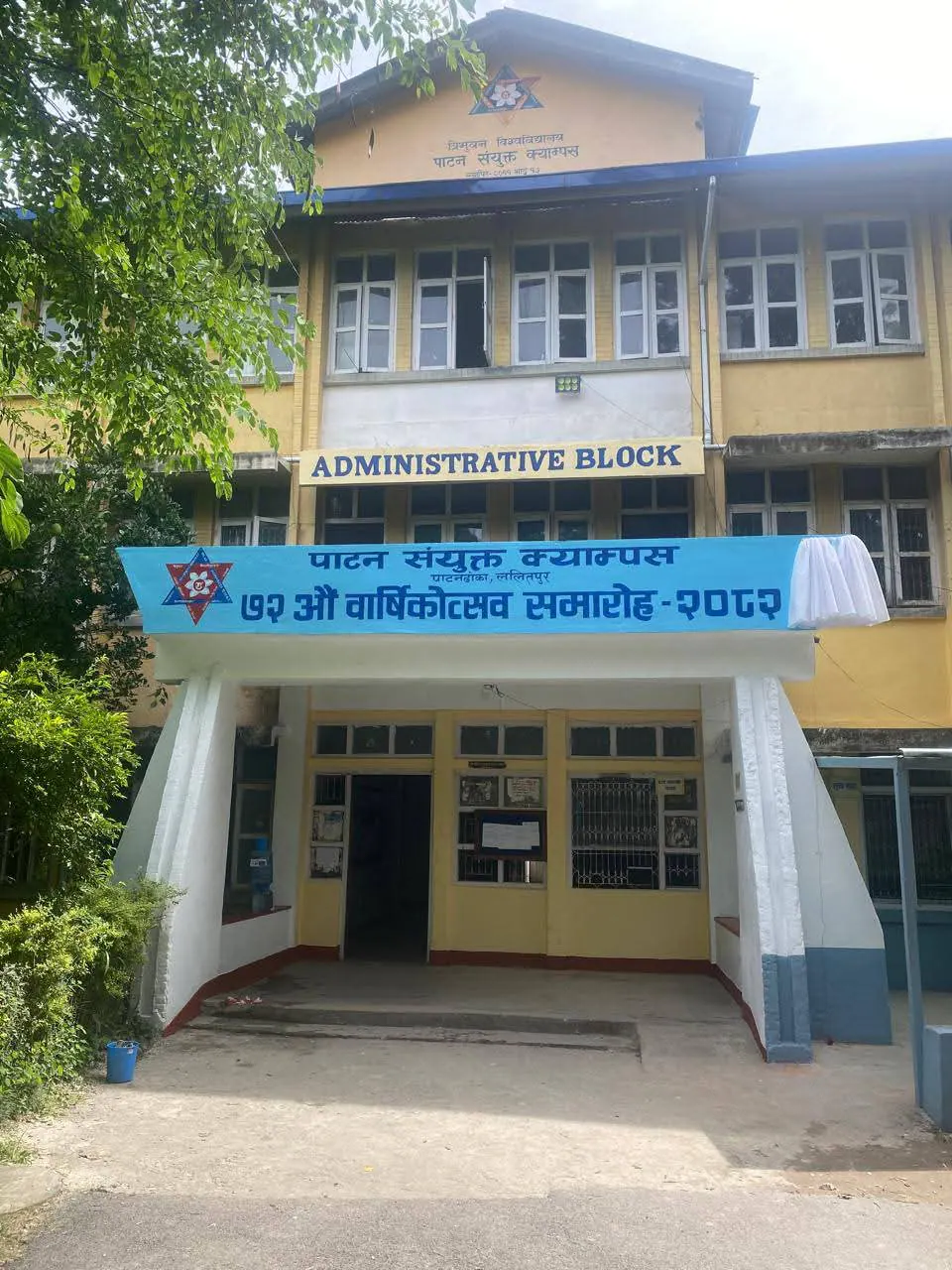 The administrative block in yellow, an anniversary banner strung above its doors