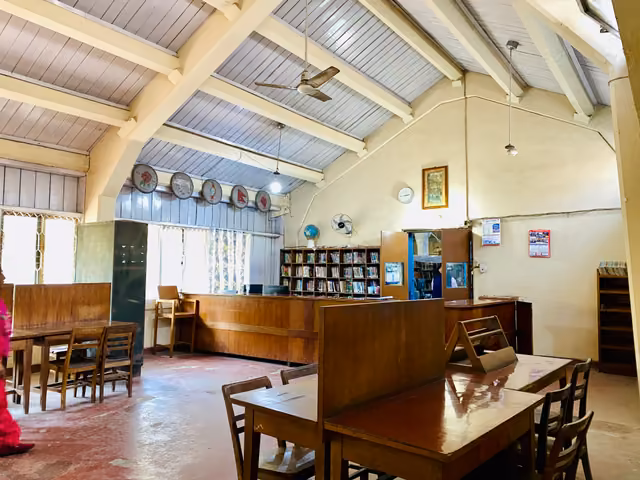 Wooden reading tables under the arched ceiling of the reading room, shelves along the far wall