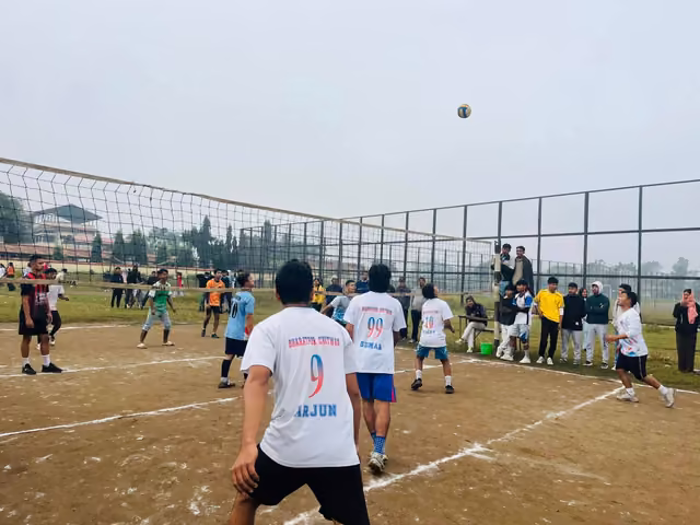 A volleyball match under way on the netted campus ground