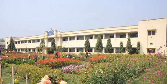 Beds of dahlias in flower in front of the long two-storey campus block